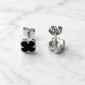 Sterling silver black quatrefoil clover stud earrings with push-back post detail on marble surface