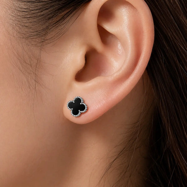 Sterling silver black quatrefoil clover stud earring worn on ear showing petite 8.5mm size