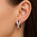 Sterling silver crisscross CZ clip earring worn on ear showing black, white, and rose-tone detail