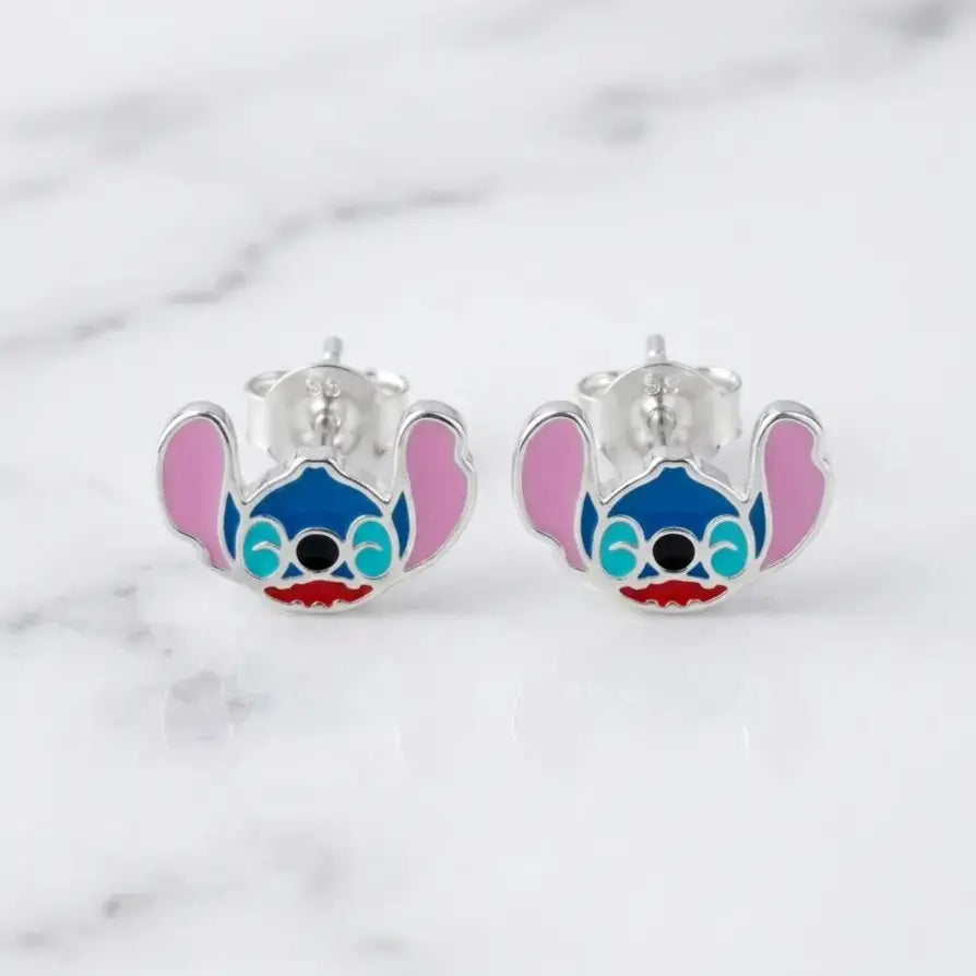Sterling silver blue alien enamel stud earrings front view with pink ears on marble surface