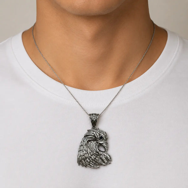 Sterling silver eagle head pendant with blue CZ eye worn on a thin chain showing size and fit