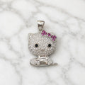 Sterling silver cat pendant with clear CZ pavé and pink bow on white marble surface