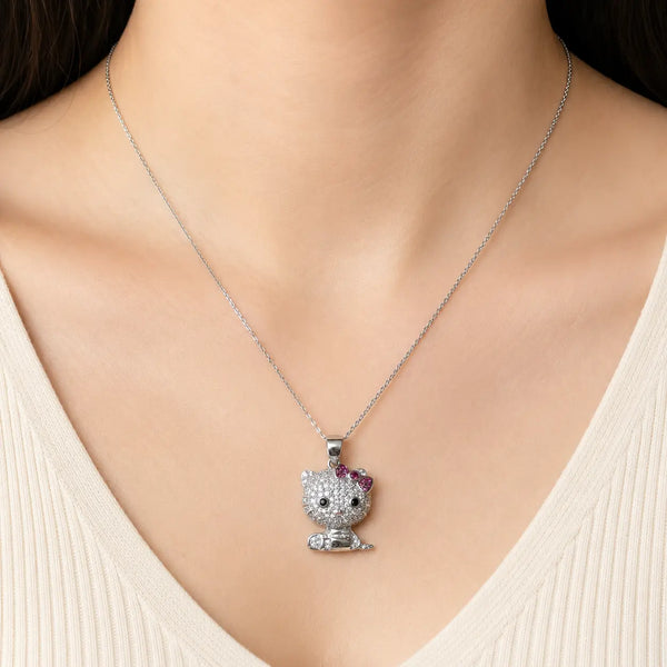 Sterling silver cat pendant with clear CZ and pink bow worn on a delicate chain at the neckline