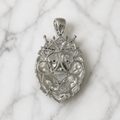 Back view of sterling silver crowned lion CZ pendant with openwork design and polished bail on marble surface