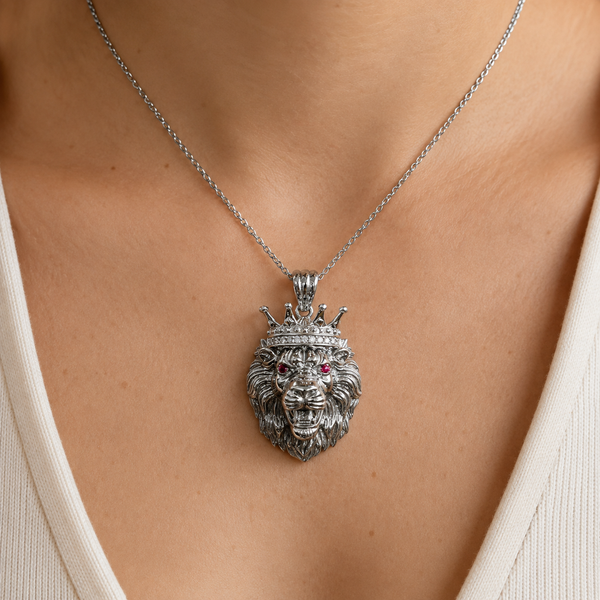 Sterling silver crowned lion pendant with red CZ eyes and white CZ crown accents worn on a silver chain