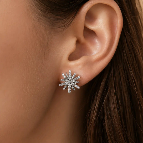 Sterling silver cubic zirconia snowflake starburst stud earring worn on ear showing size and fit