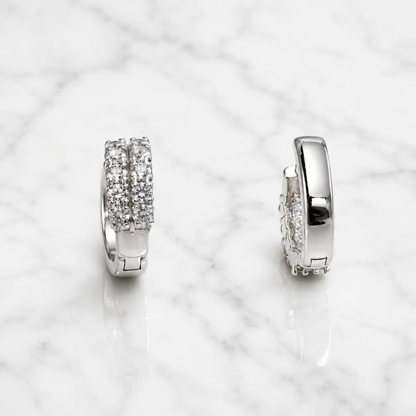 Sterling silver double-row CZ huggie earrings front and side view on marble surface
