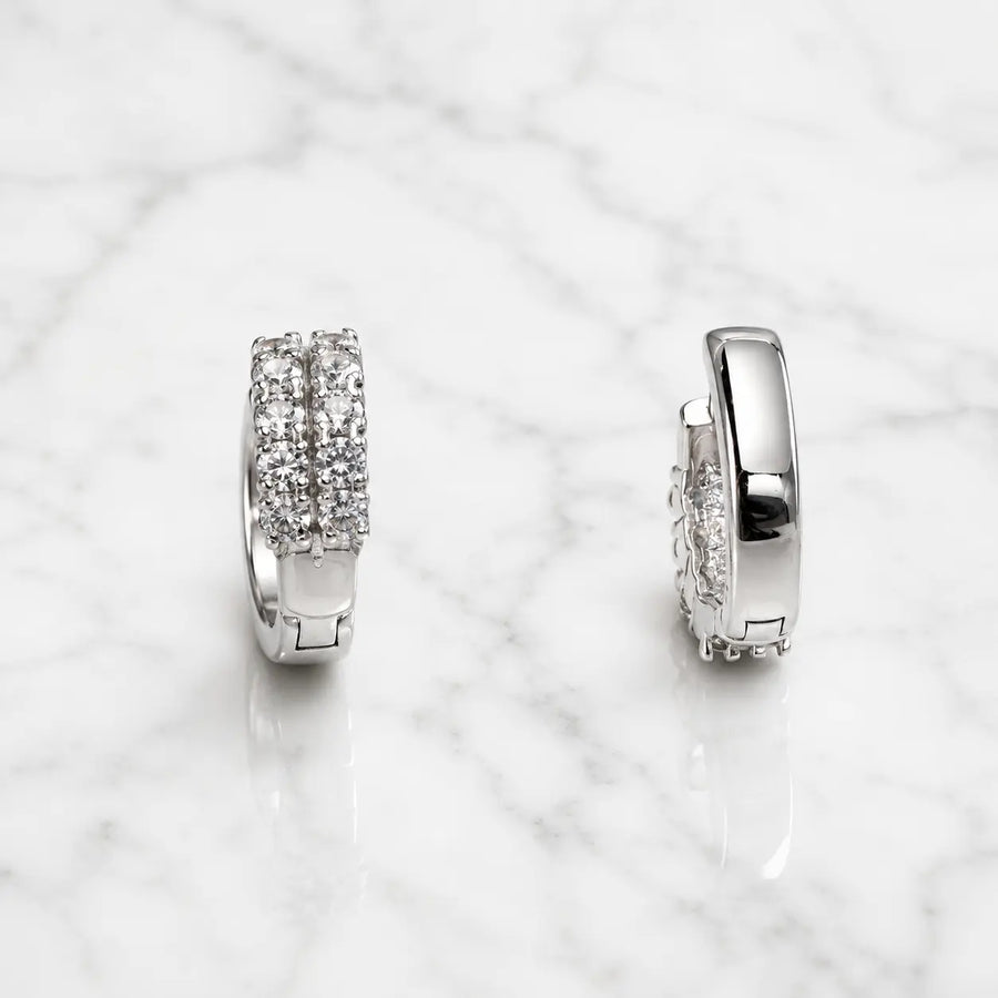 Sterling silver double-row CZ huggie earrings front and side view on marble surface