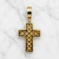 Back view of gold tone sterling silver crucifix pendant with polished openwork design on marble surface