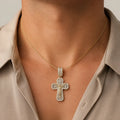 Gold tone sterling silver CZ crucifix pendant worn on a fine chain and shown on neck for scale