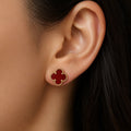 Sterling silver gold-tone red clover stud earrings front pair with beaded border on marble surface