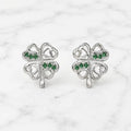 Sterling silver green CZ clover stud earrings front pair with heart cutouts on marble surface
