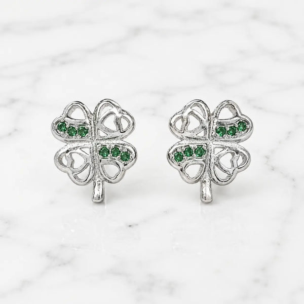 Sterling silver green CZ clover stud earrings front pair with heart cutouts on marble surface