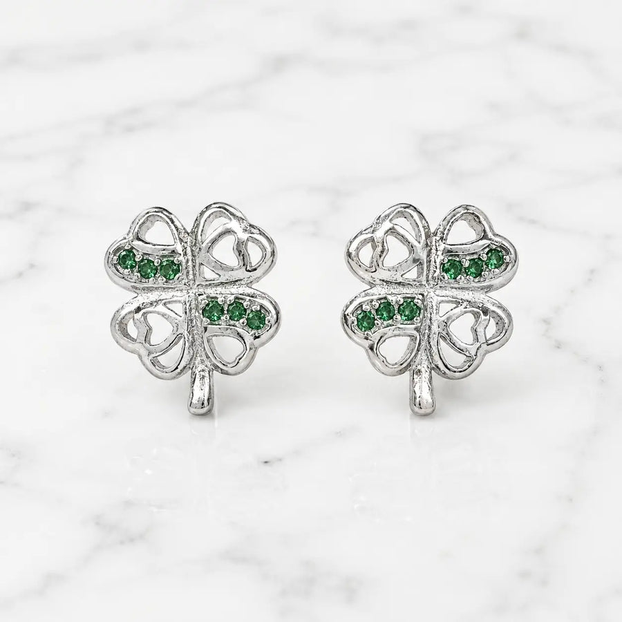 Sterling silver green CZ clover stud earrings front pair with heart cutouts on marble surface