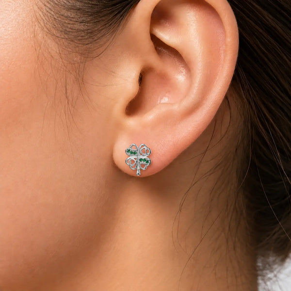 Sterling silver green CZ clover stud earring worn on ear showing petite shamrock size and heart cutouts