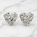 Sterling silver large diamond-cut heart stud earrings front view pair on marble surface