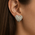 Sterling silver large diamond-cut heart stud earring worn on ear showing bold heart size