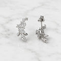 Sterling silver marquise CZ floral stud earrings with push-back post detail on marble surface