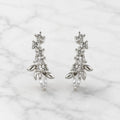 Sterling silver marquise CZ floral stud earrings front pair with round CZ accents on marble surface