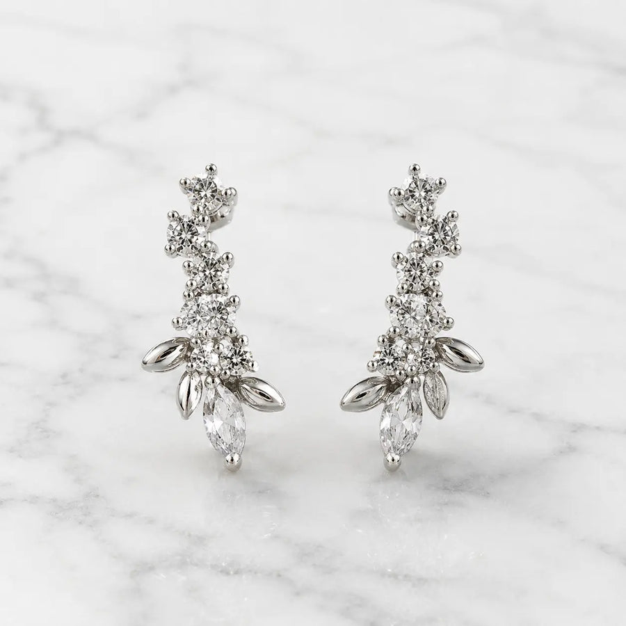Sterling silver marquise CZ floral stud earrings front pair with round CZ accents on marble surface