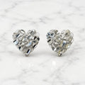 Sterling silver medium diamond-cut heart stud earrings front view pair on marble surface
