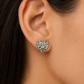 Sterling silver medium diamond-cut heart stud earring worn on ear showing everyday scale