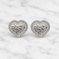 Sterling silver textured heart CZ stud earrings with pavé-style border on marble surface