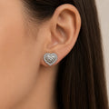 Sterling silver heart CZ stud earrings worn on ear showing scale, shape, and textured center
