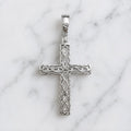 Sterling silver ornate crucifix pendant back view with openwork detailing and polished bail on white marble surface