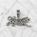 Back view of sterling silver panther pendant showing open CZ settings and polished framework on marble surface