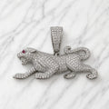Sterling silver panther pendant with clear pavé CZ and red CZ eye accent on marble surface