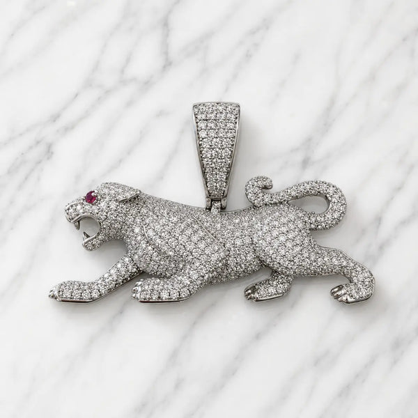 Sterling silver panther pendant with clear pavé CZ and red CZ eye accent on marble surface