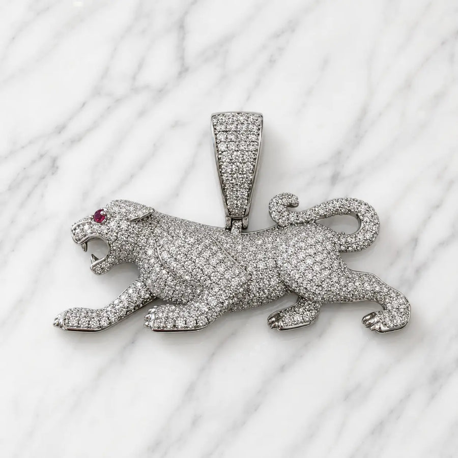 Sterling silver panther pendant with clear pavé CZ and red CZ eye accent on marble surface