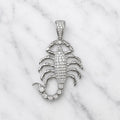 Sterling silver scorpion pendant with pavé clear CZ body, tail and bail shown front-facing on marble surface