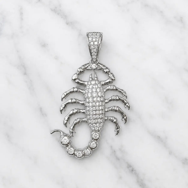 Sterling silver scorpion pendant with pavé clear CZ body, tail and bail shown front-facing on marble surface