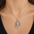 Sterling silver CZ scorpion pendant worn on a thin chain at the neckline showing its statement-size design