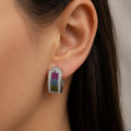 Sterling silver rainbow CZ huggie earring worn on ear showing colorful stones and close-to-the-ear fit