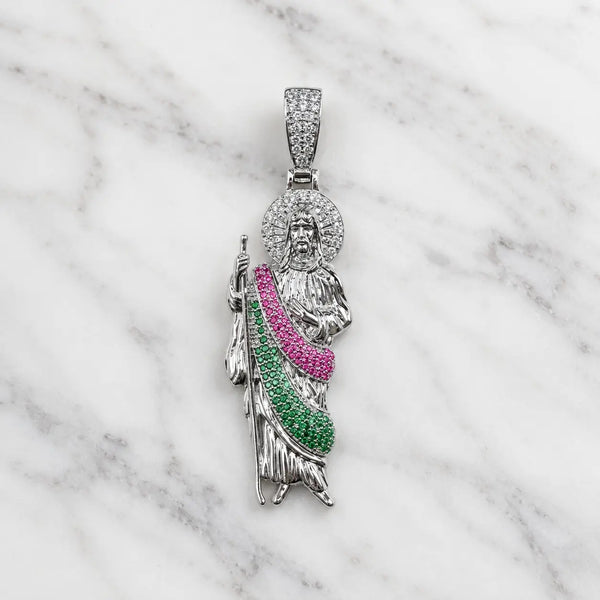 Sterling silver Saint Jude pendant with clear halo and pink and green CZ robe on marble surface