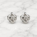 Sterling silver small diamond-cut heart stud earrings front view pair on marble surface