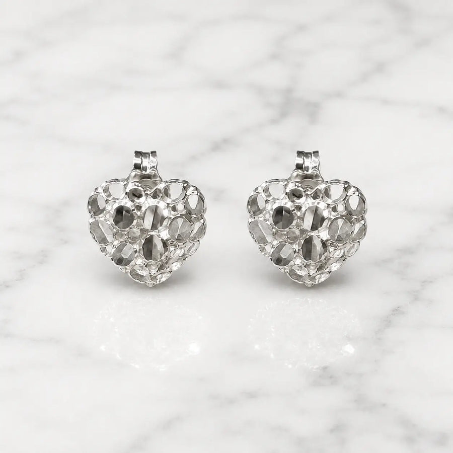 Sterling silver small diamond-cut heart stud earrings front view pair on marble surface