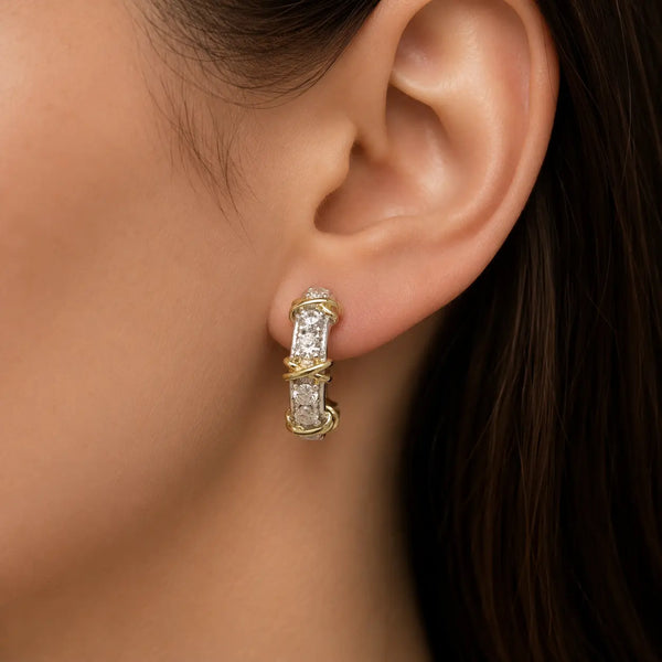 Sterling silver two-tone CZ crossover screw-back earring worn on ear showing curved half-hoop style