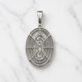 Back view of sterling silver Virgin Mary pendant showing openwork oval gallery and stone backing on marble surface