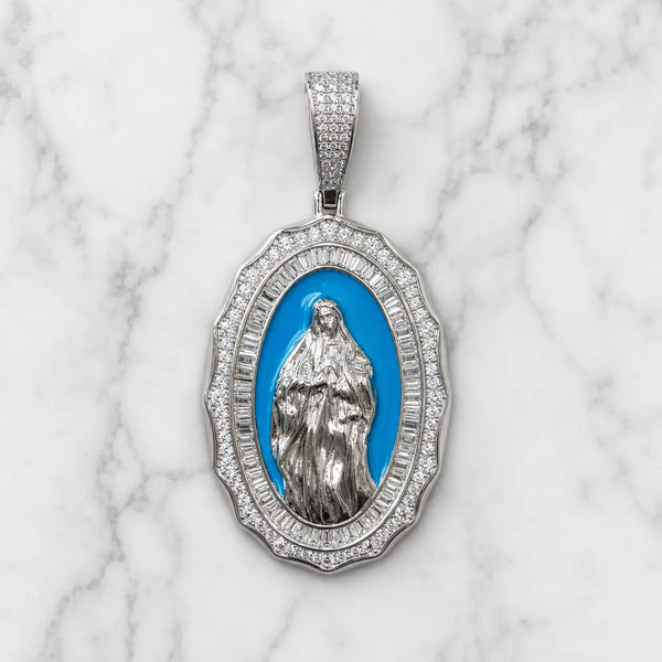 Front view of sterling silver Virgin Mary oval pendant with white CZ border and blue center on marble surface