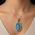 Sterling silver Virgin Mary white CZ oval pendant worn on a thin chain showing scale and fit