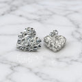 Sterling silver x-large diamond-cut heart stud earrings front and back view on marble surface