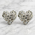 Sterling silver x-large diamond-cut heart stud earrings front view pair on marble surface
