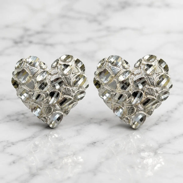 Sterling silver x-large diamond-cut heart stud earrings front view pair on marble surface