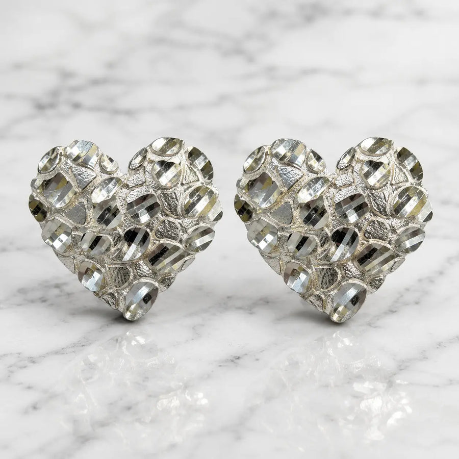 Sterling silver x-large diamond-cut heart stud earrings front view pair on marble surface