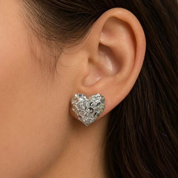 Sterling silver x-large diamond-cut heart stud earring worn on ear showing statement size