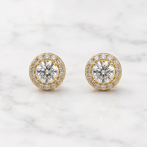 Yellow gold tone sterling silver 1 CTW moissanite halo stud earrings in a straight-on front view on marble